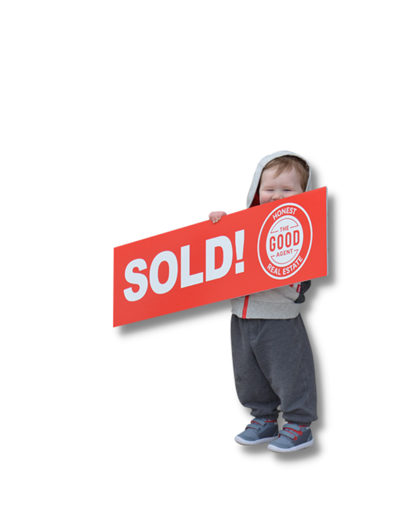 Toddler holding SOLD by The Good Agent sign