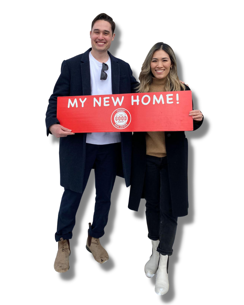 Couple holding a The Good Agent purchased a home sign